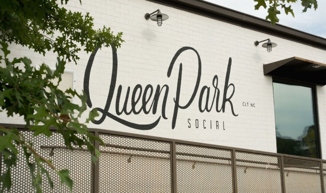 a sign with trees out front